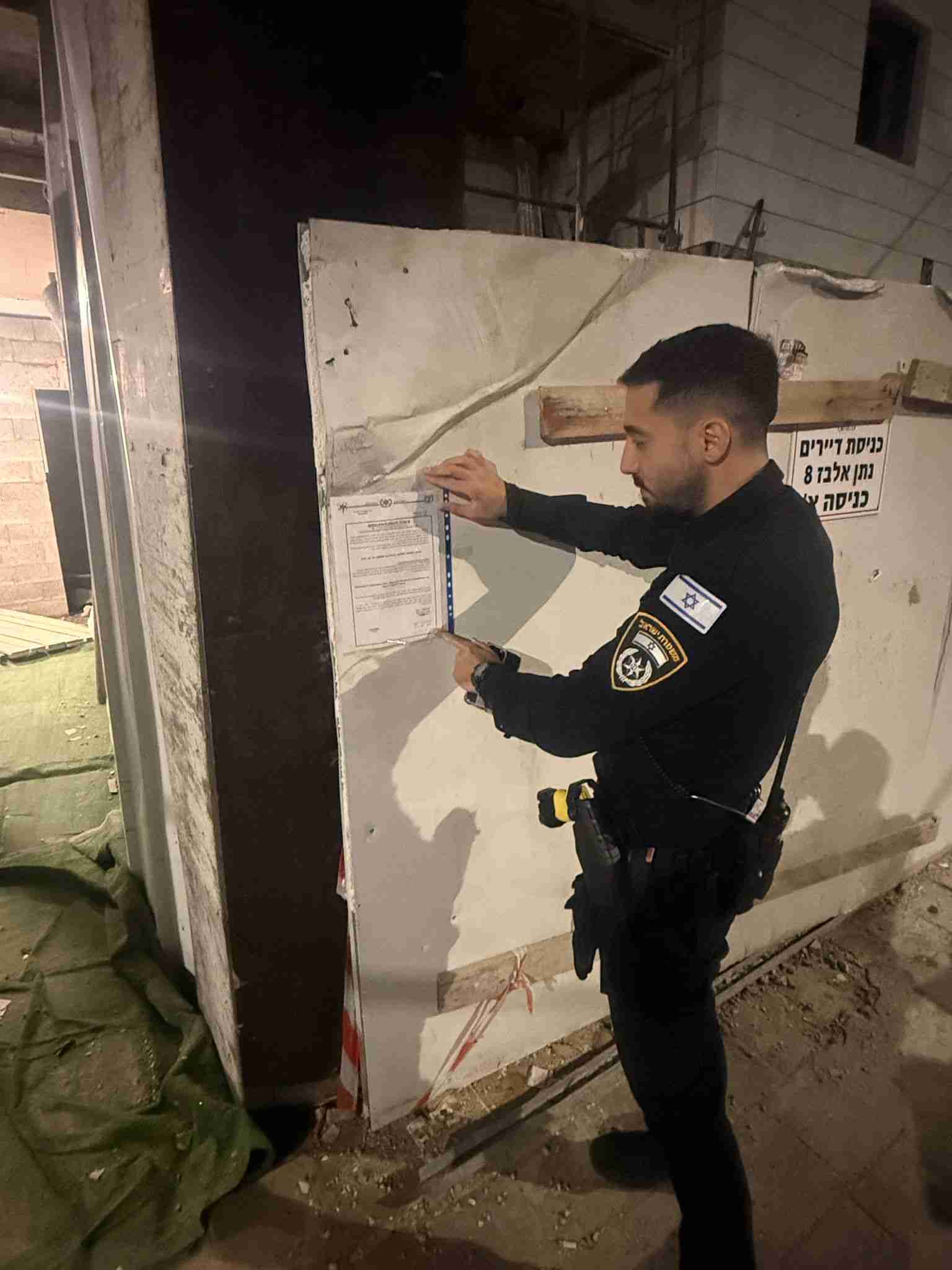 הדבקת הצו על גדר האתר באשדוד. צילום: דוברות המשטרה